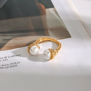 Detail of gold titanium steel open ring with dual pearls and textured band surface