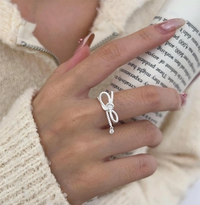 Detail of S925 silver bow ring with vintage rope texture and hanging zircon stone