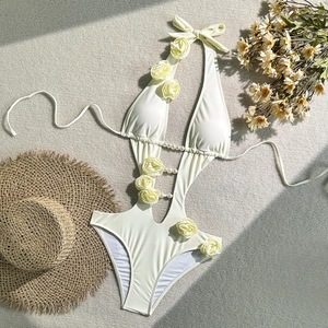 Detail of cream white one-piece swimsuit with 3D floral appliques and pearl beaded cut-out