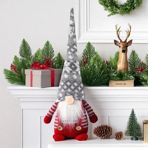 Détail d'un gnome de Noël en peluche avec bonnet tricoté et barbe blanche sur manteau