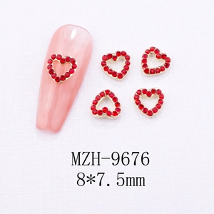 Detail of red rhinestone heart nail charms with gold metal base for DIY manicure art