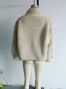 Rear view of cream-colored plush fleece jacket showing thick faux fur texture for winter