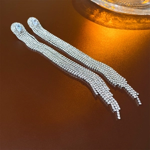 Detailed close-up of long silver tassel earrings with sparkling white crystals