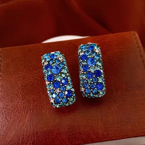 Boucles d'oreilles rectangulaires vintage en or avec cristaux bleus sur surface en cuir