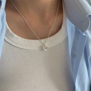 Minimalist 925 sterling silver heart knot pendant necklace worn for elegant styling