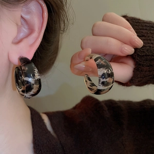 Detailed view of leopard print resin C-shaped earrings with smooth acrylic texture