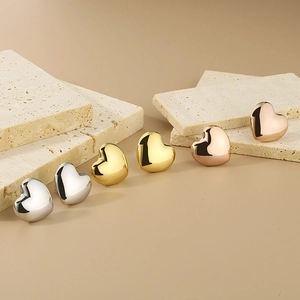 Detailed view of 3D hollow heart stud earrings in silver, gold, and rose gold finishes
