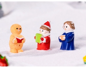 Detailed view of choir resin figurines including gingerbread man on snow background