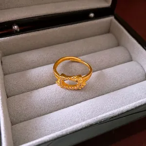 Gold-plated cat and flower ring with zircon inlays on a gray velvet jewelry box