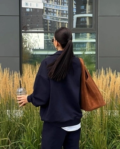 Photo de rue en extérieur vue de dos d'un sweat à demi-zip bleu marine et d'un pantalon ample