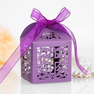 Macro view of purple laser-cut gift box with satin ribbon and geometric hollow pattern