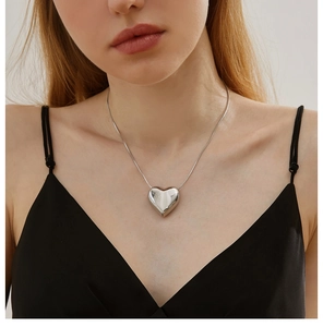 Close-up of a silver heart pendant necklace on a delicate snake chain for women