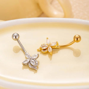 Macro shot of silver and gold flower belly rings with marquise cubic zirconia detail