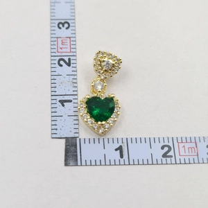 Size scale view of a gold heart pendant with green gemstone and zircon stones