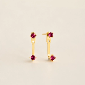 Polished gold birthstone earrings with double rose red gems in a modern minimalist style
