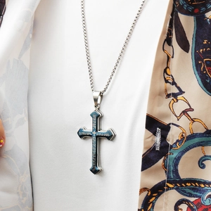 Detail showing double-layered blue and silver cross pendant with engraved Lord's Prayer