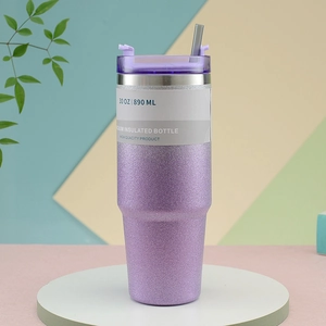 Close-up of a 30oz purple glitter vacuum insulated tumbler with lid and straw on a display