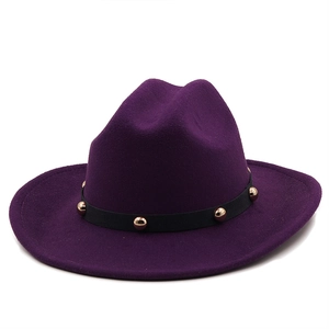 Detail of dark purple fedora hat featuring a black ribbon band and golden metal studs