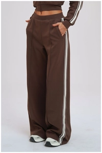 Detail shot of high-waist loose sport pants in dark coffee with side white stripes