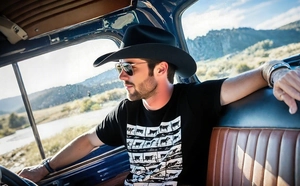 Detail of a black western cowboy hat and aviator sunglasses inside a vintage car interior