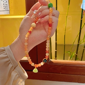 Detail of Chinese beaded necklace with orange agate beads and lotus pendant charm