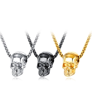 Close-up of hip hop skull pendants in polished silver, black, and gold stainless steel