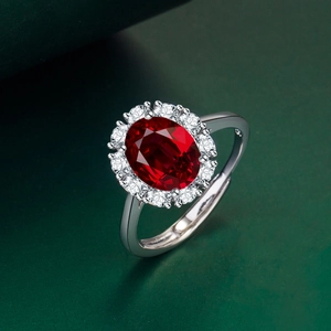 Close-up of luxury oval red gemstone ring with white crystals on green background