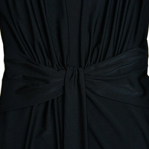 Gros plan détaillé de la robe noire avec taille plissée et design à nœud central