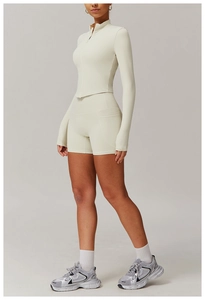 Détail d'un ensemble de yoga crème avec haut à manches longues et short de sport taille haute