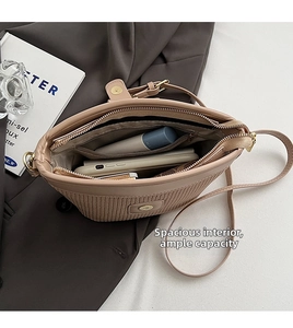 Close-up of the beige woven bag interior showing spacious capacity and secure gold zipper