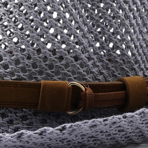 Close-up of woven straw jazz hat texture with blue-grey finish and brown suede belt