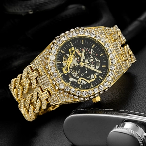 Close-up of gold iced-out mechanical watch with skeleton dial and diamond encrusted band