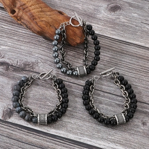 Detail of tiger eye and stone beaded bracelets with OT clasp on vintage wood