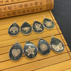 Teardrop natural stone pendants with Tree of Life and animal motifs on bamboo background