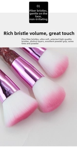 Macro shot of soft pink gradient fiber bristles and glitter handle makeup brush