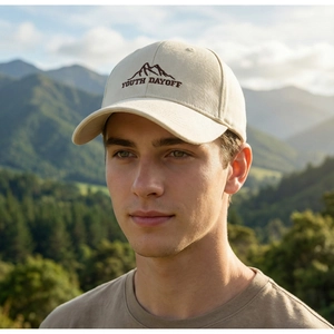 Close-up of beige cotton baseball cap with mountain embroidery and Youth Dayoff text
