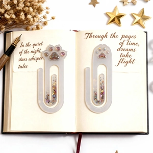 Detail of creative resin cat paw bookmarks with colorful glitter on a notebook page