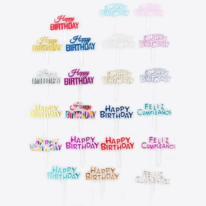 Various colorful Happy Birthday and Feliz Cumpleaños cake toppers in gold and acrylic finish