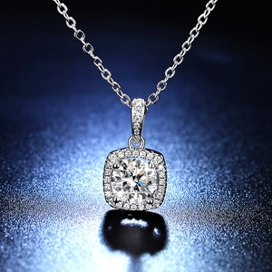 Macro shot of 1 carat moissanite halo pendant with brilliant round cut on a navy base