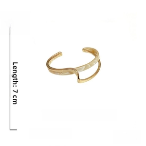 Detail view of irregular gold-plated geometric double-layer bangle with shell inlay