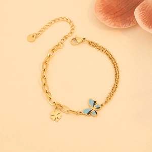 Bracelet doré avec pendentifs papillon et trèfle et design de chaînes combinées