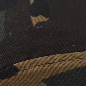 Macro shot of cotton camouflage twill fabric with precision stitching detail