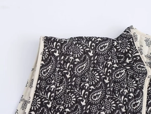 Dettaglio del gilet trapuntato reversibile con motivo paisley bianco e nero e bordi beige