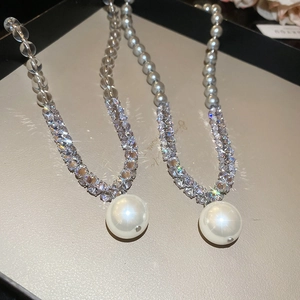 Macro shot of silver crystal beaded necklace with large white pearl pendants in gift box