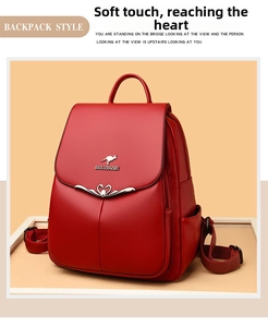Detail of red leather backpack featuring gold kangaroo logo and heart-shaped metal trim