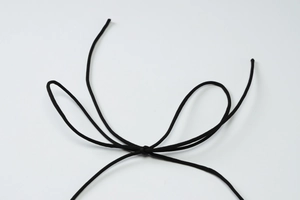 Détail du nœud en dentelle noire mince sur un ensemble en peluche à imprimé léopard