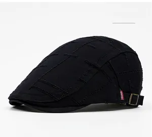 Detail of black cotton flat cap featuring distressed stitching and red Fashion tag