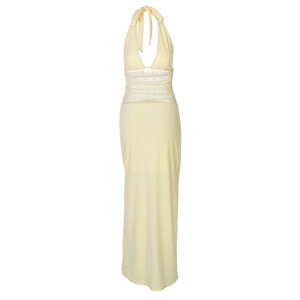 Detail of the pale yellow backless maxi dress with sheer mesh paneling and halter neck style