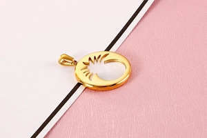 Detail of a golden round metal pendant featuring an abstract hollow pineapple pattern