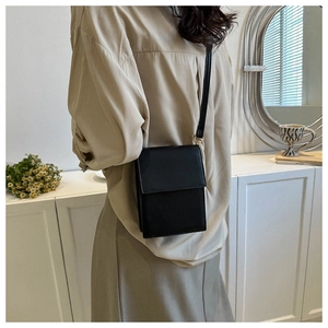Détail d'un sac bandoulière noir minimaliste montrant sa texture lisse et son style quotidien
